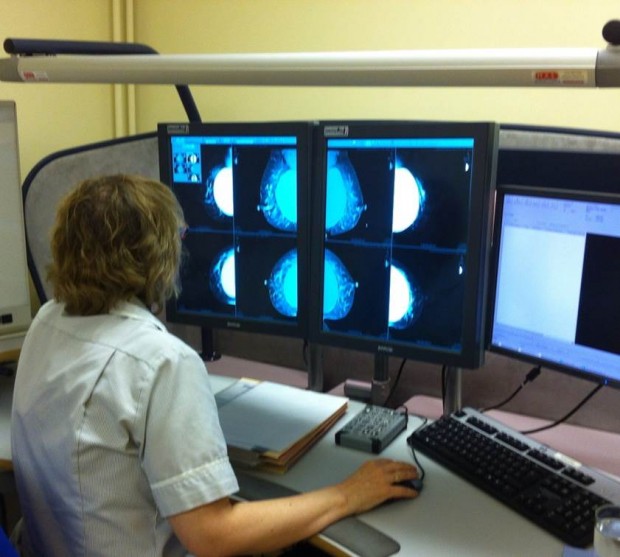 Woman looking at mammogram results on a number of screens.