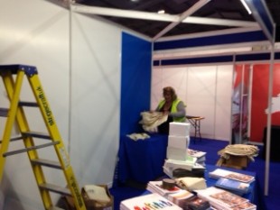 A member of staff setting up for the conference with a step-ladder nearby.