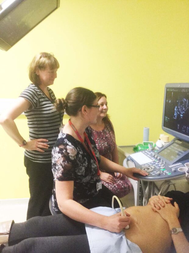 Healthcare staff practising sonography on a pregnant woman.