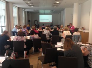 A room full of people sat in chairs during a workshop.