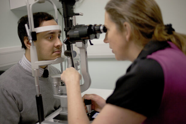 A man having a sight test using a slit lamp