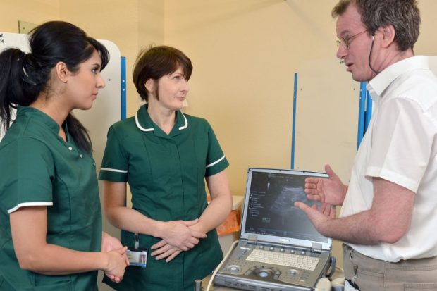 A group of medical professionals discussing a scan.