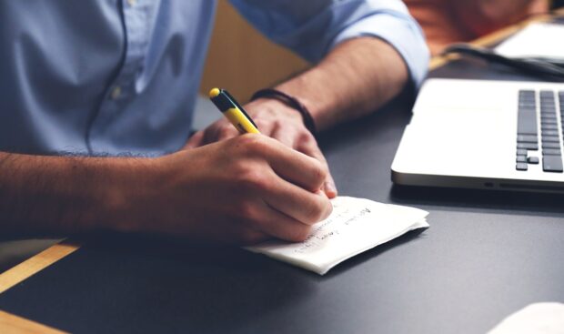 A man writing at a desk.