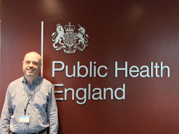 Image of Nick Johnstone-Waddell in front of the PHE logo.