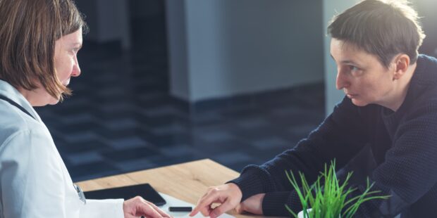 Male patient in consultation with female doctor