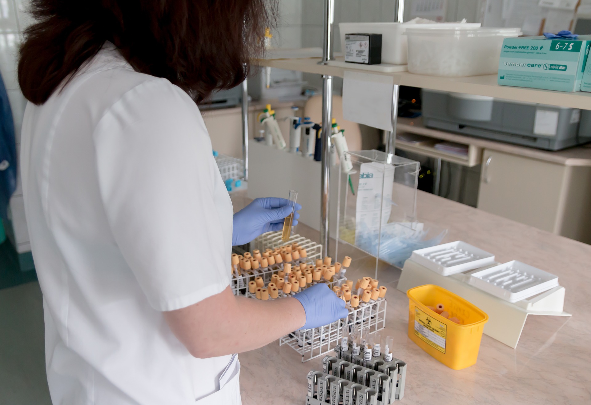 A woman inserts sample test tubes into slots