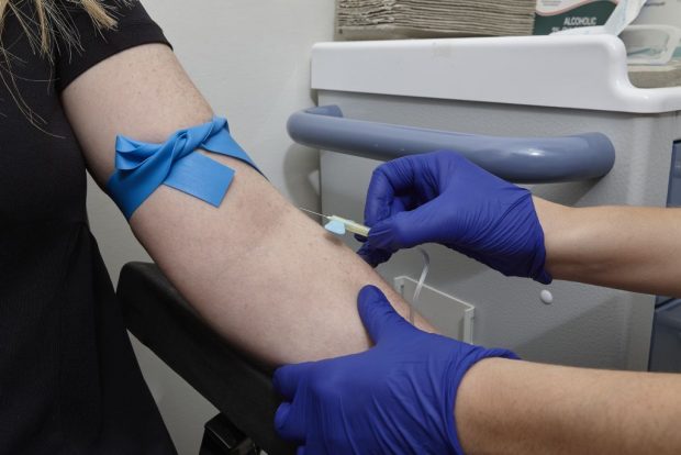 Young person having an injection in their arm.