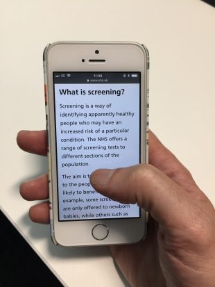 A person uses their mobile phone to get information about screening on NHS.UK