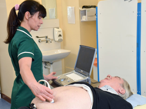 A nurse carrying out a AAA screening test