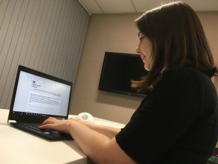Woman shown filling in our online survey on her laptop