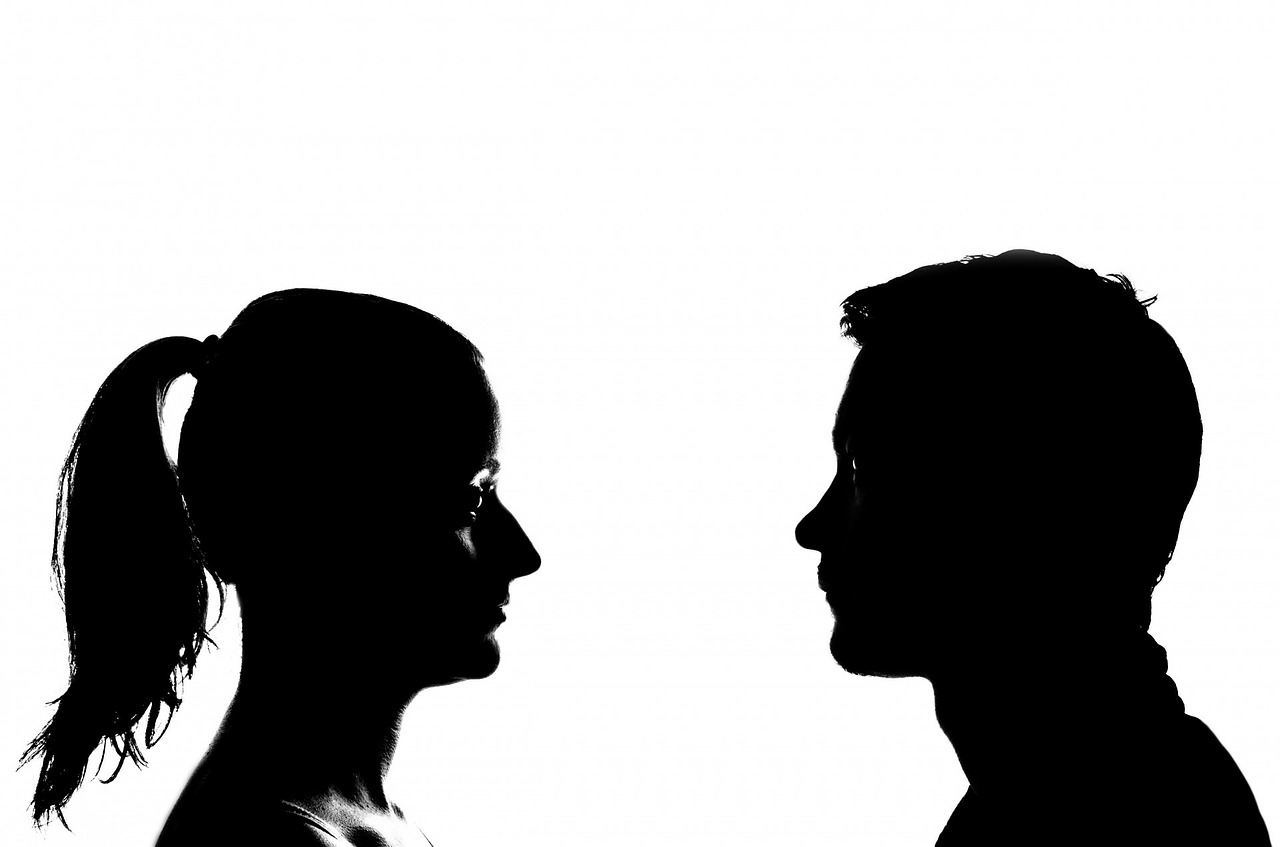 A woman and a man face each other.