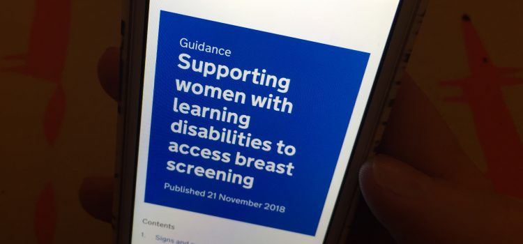Photo shows a person holding a mobile phone displaying the words Supporting women with learning disabilities to access breast screening.