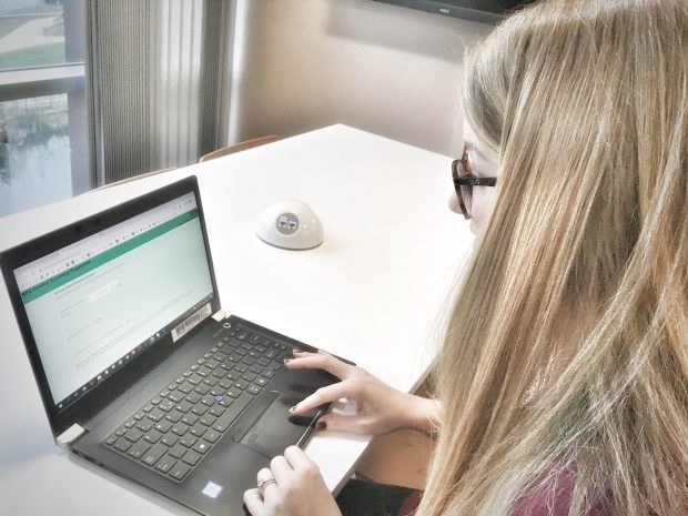 Photo showing woman on a laptop using the old cervical screening extranet site