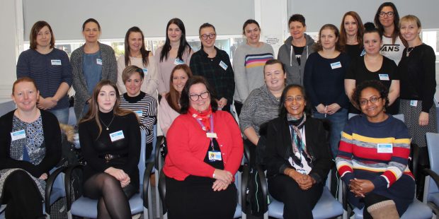 18 mammography associate practitioner apprentices sitting together and smiling at the camera