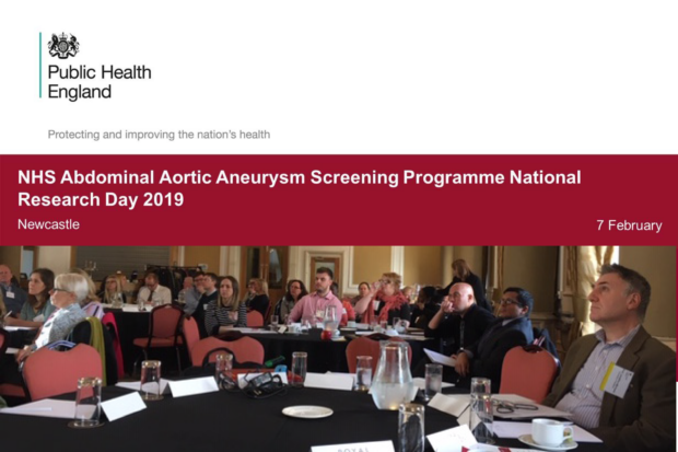 A presentation slide at the event with the title 'NHS Abdominal Aortic Aneurysm Screening Programme National Research Day 2019, Newcastle, 7 February' above a photograph of delegates sitting at tables listening to presentation at the national AAA screening research event held in Newcastle