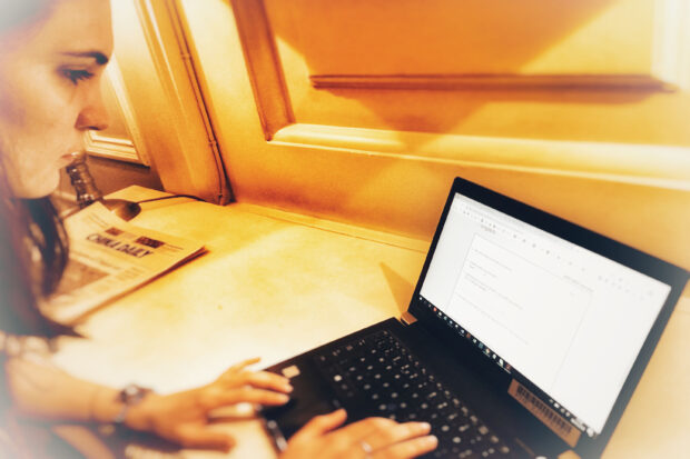 A woman sitting in front of laptop filling in the online survey