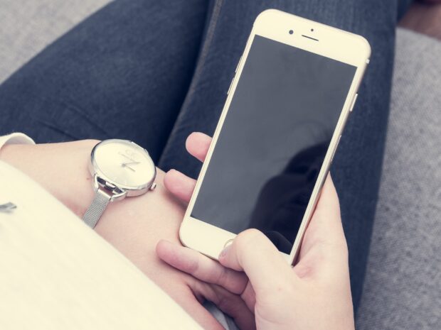 A closeup of a woman's hands holding a smartphone