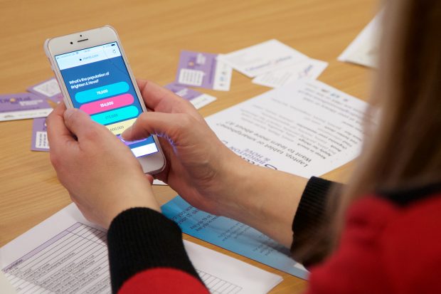 A person uses their mobile phone to view screening information.