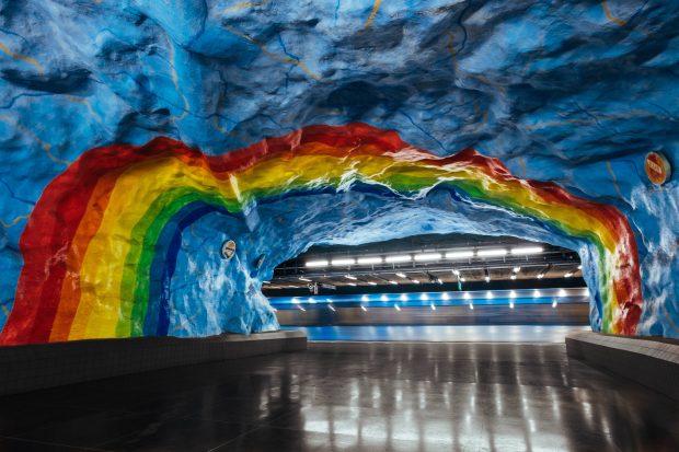A tunnel painted to look like a rainbow in the sky