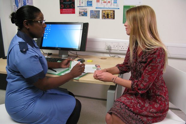 Pregnant woman in consultation with screening midwife