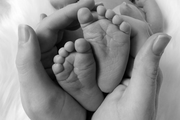 hands formed around a baby's feet