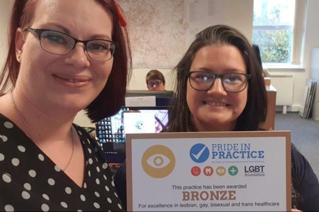 Two women (Alex Matheson and Sara Gill) holding up a certificate