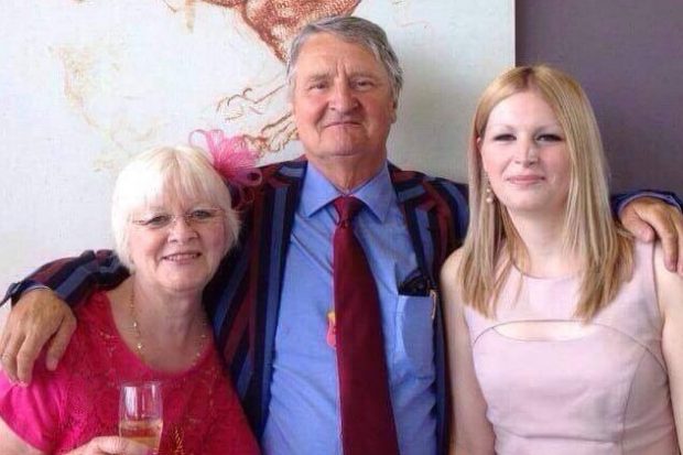 A man standing with 2 women smiling at the camera